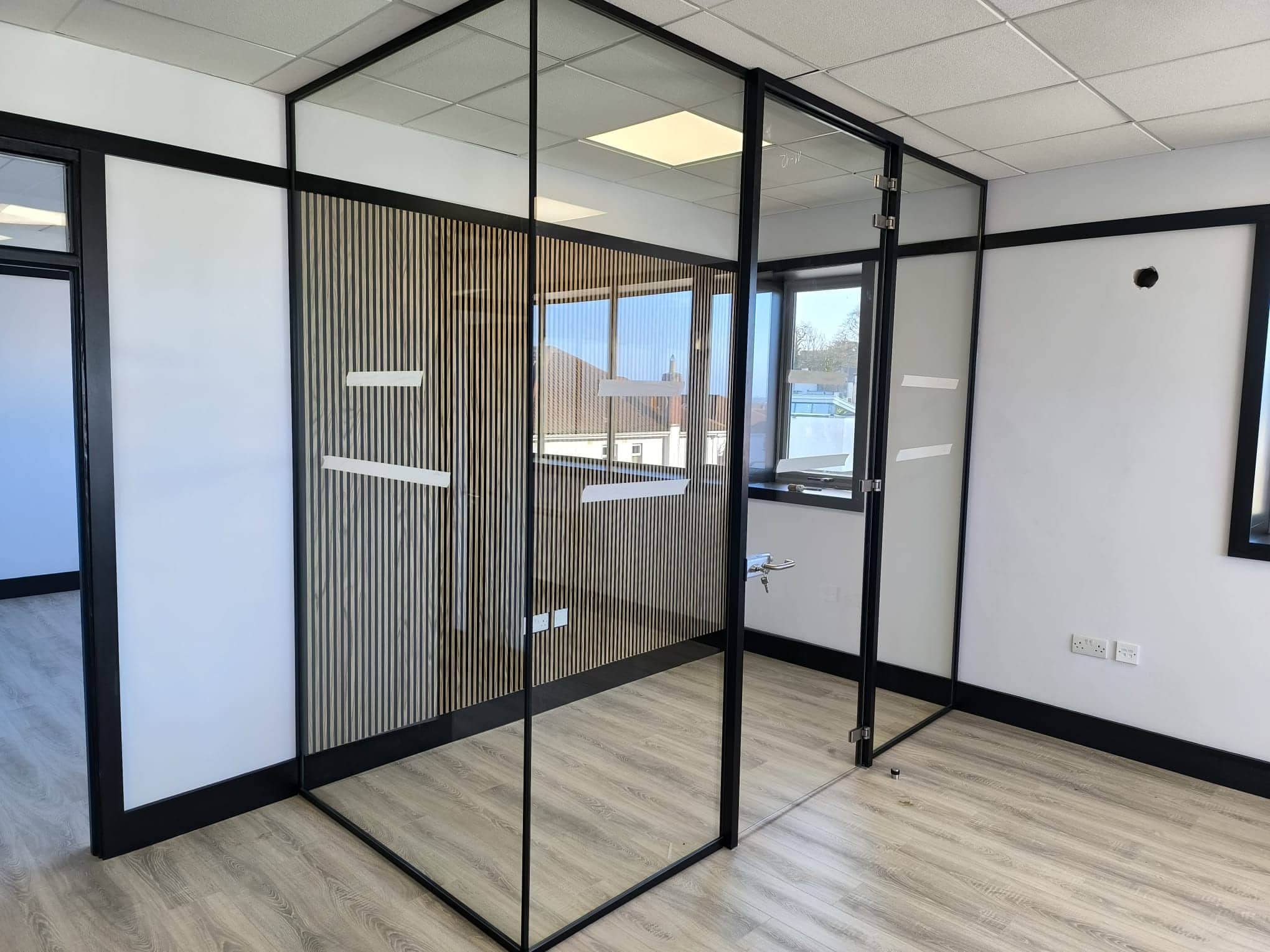 Black-framed glass office partitions with oak detailing